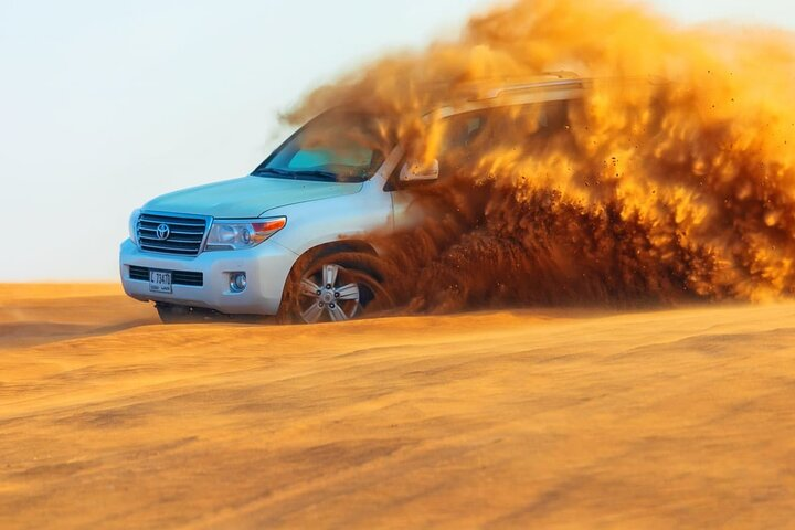 Experience the thrill of speeding across golden dunes in a 4WD creating unforgettable moments amidst the stunning desert landscape of Dubai's Lahbab. Enjoy the ride!